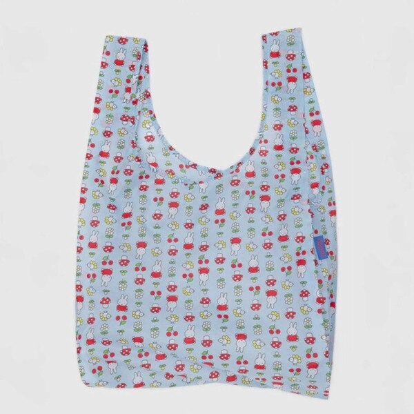 Light blue reusable BAGGU bag with allover Miffy, mushroom, and flower pattern in red, white, yellow, and green